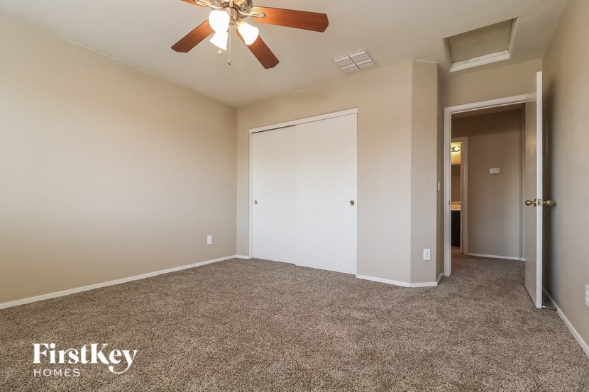 a bedroom with carpeted flooring and a ceiling fan