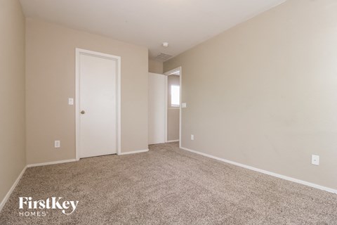 a bedroom with carpet and a door to a closet