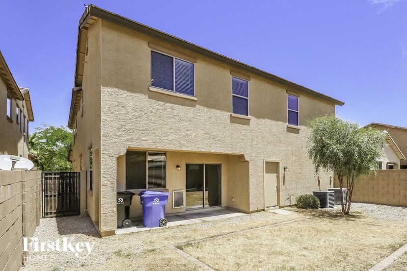 a brick house with a yard and a trash can