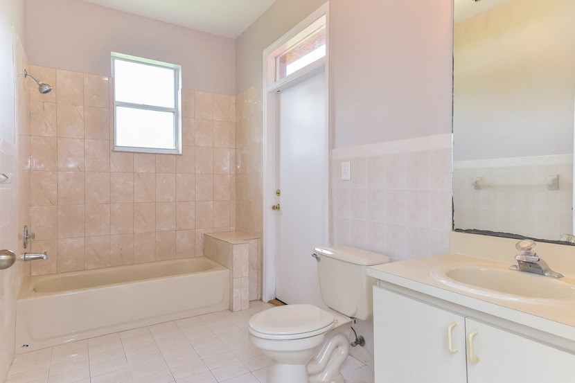 a bathroom with a toilet and a sink and a bath tub