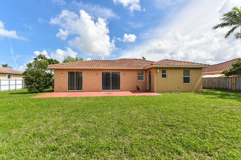 a small house with a yard and a fence