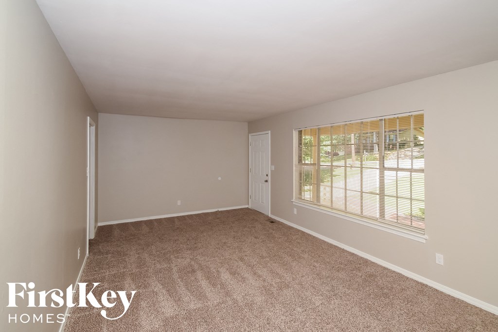 a bedroom with carpet and a large window