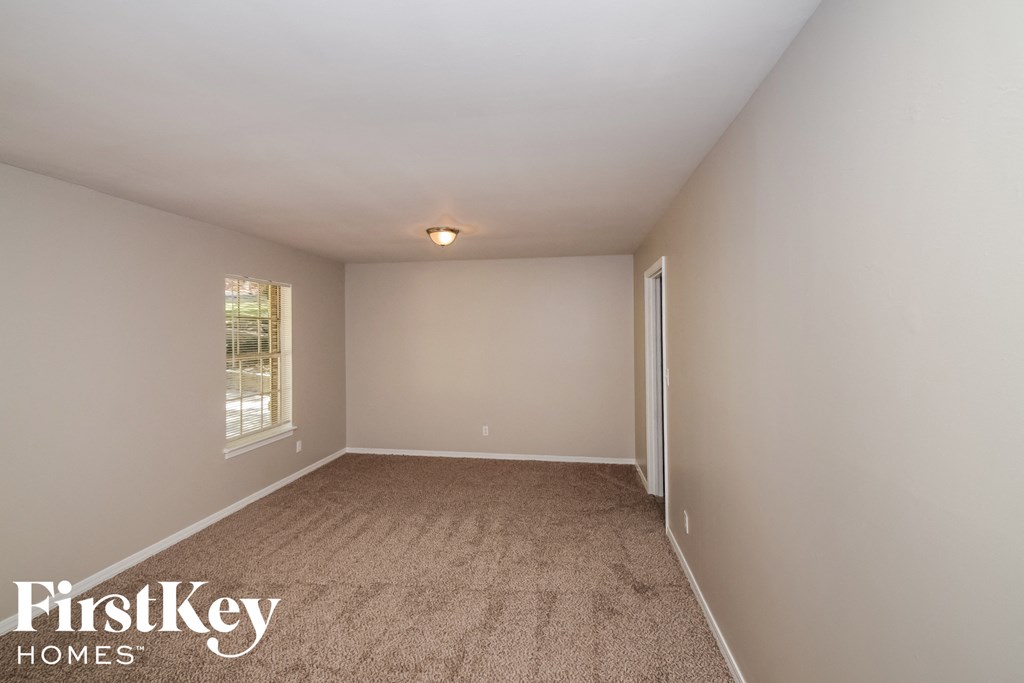 a bedroom with a carpeted floor and a window