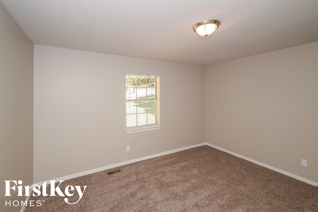 a bedroom with a carpeted floor and a window