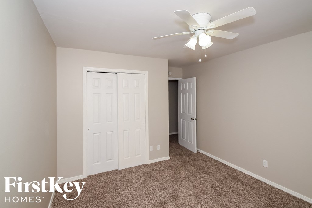 a bedroom with two closets and a ceiling fan