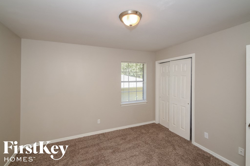 the upstairs bedroom with carpet and a door to the backyard
