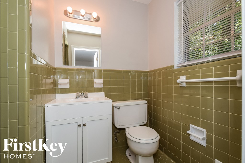 a bathroom with a toilet sink and a mirror