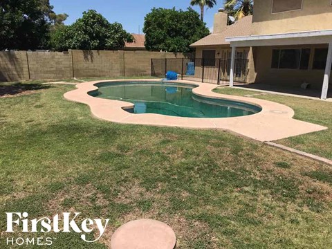 a backyard with a swimming pool and a house