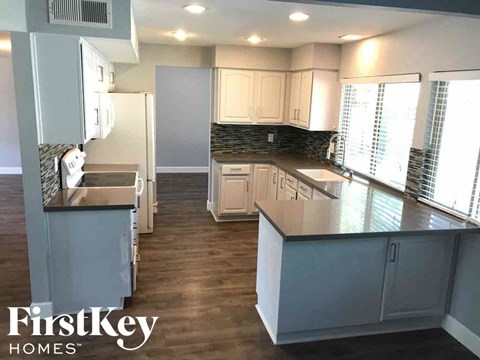 a kitchen with white cabinets and a large counter top