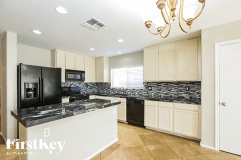A kitchen with a black fridge and a black dishwasher.
