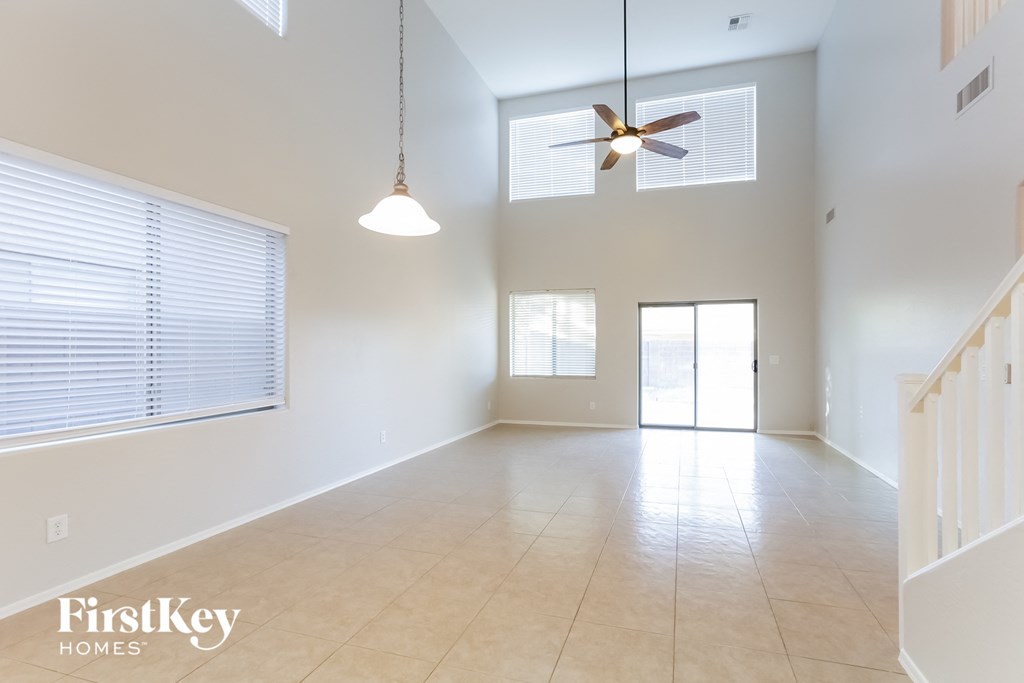 A spacious room with a ceiling fan and a light hanging from the ceiling.