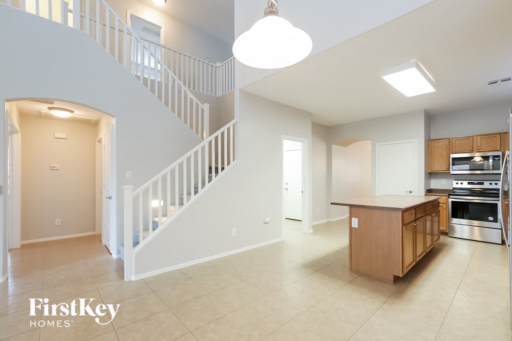 A spacious kitchen and living room with a staircase.
