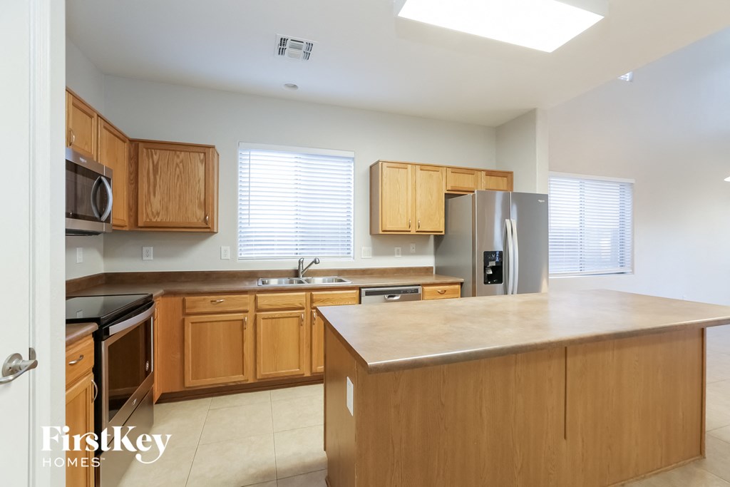 A kitchen with wooden cabinets and a refrigerator.