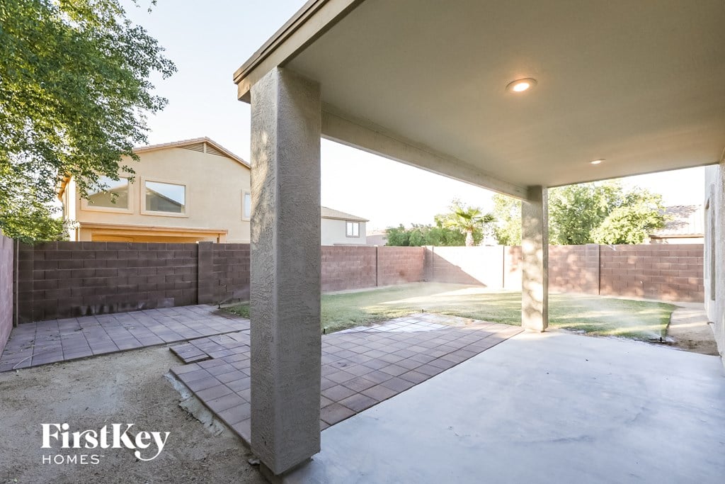 A patio area with a concrete floor and pillars.