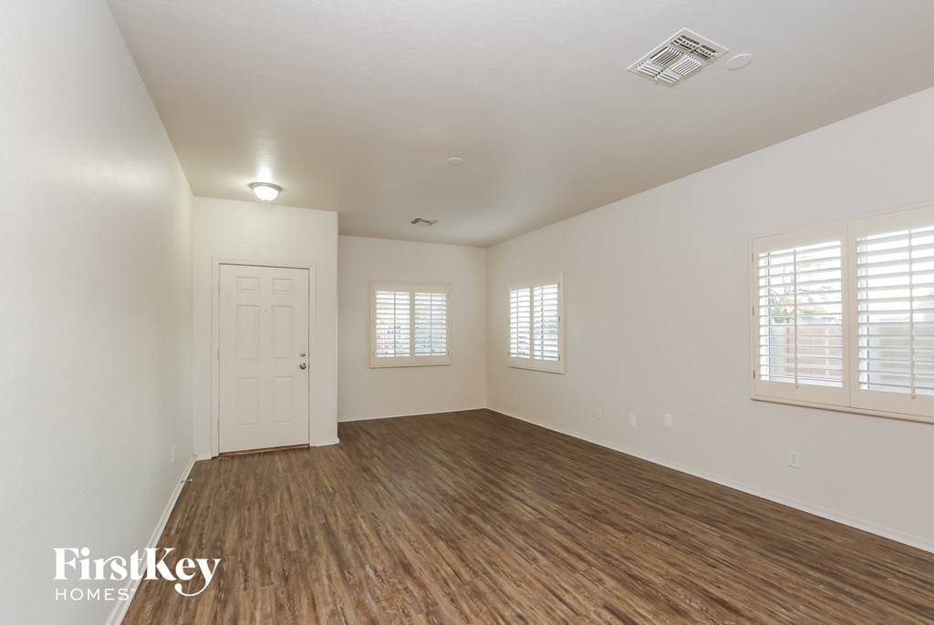 a living room with a hard wood floor and a white door