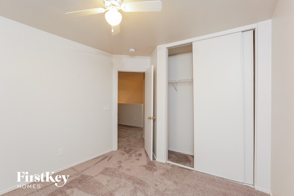 a bedroom with a closet and a ceiling fan