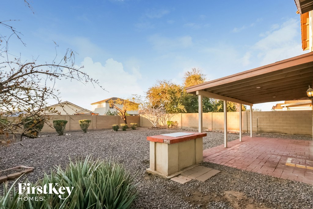 a backyard with a barbecue grill and a house