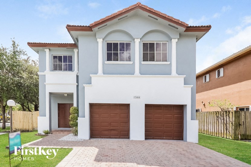 a white and blue house with two garage doors