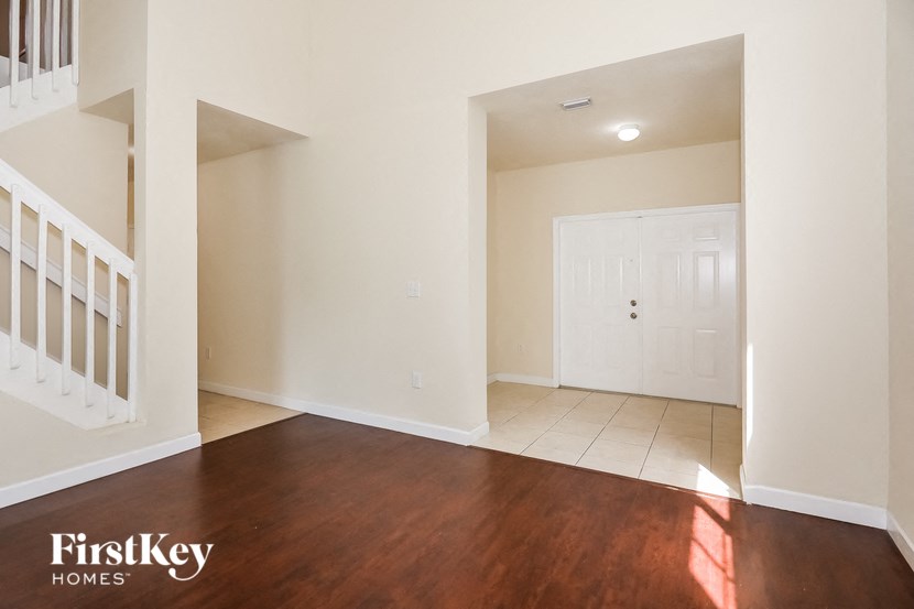 an empty living room with wood flooring and a white door