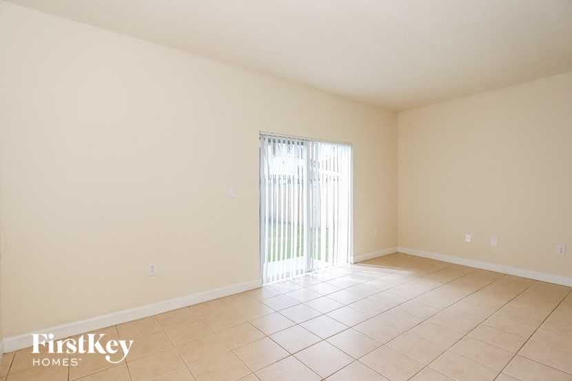 an empty living room with a sliding glass door to a patio