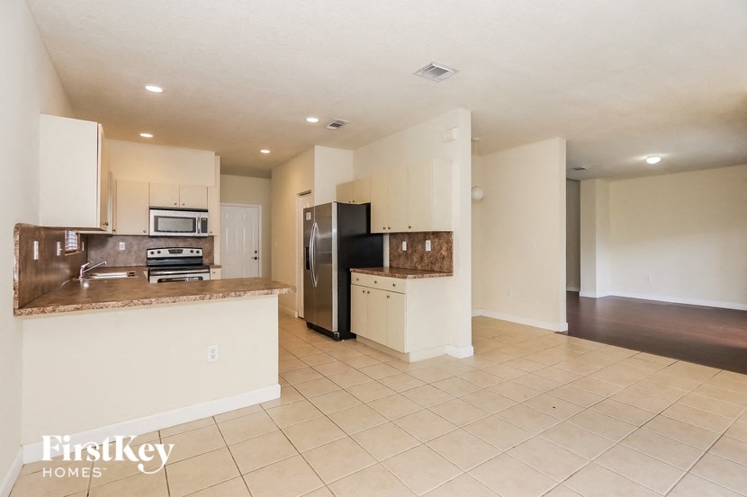 a kitchen with an island and a stainless steel refrigerator