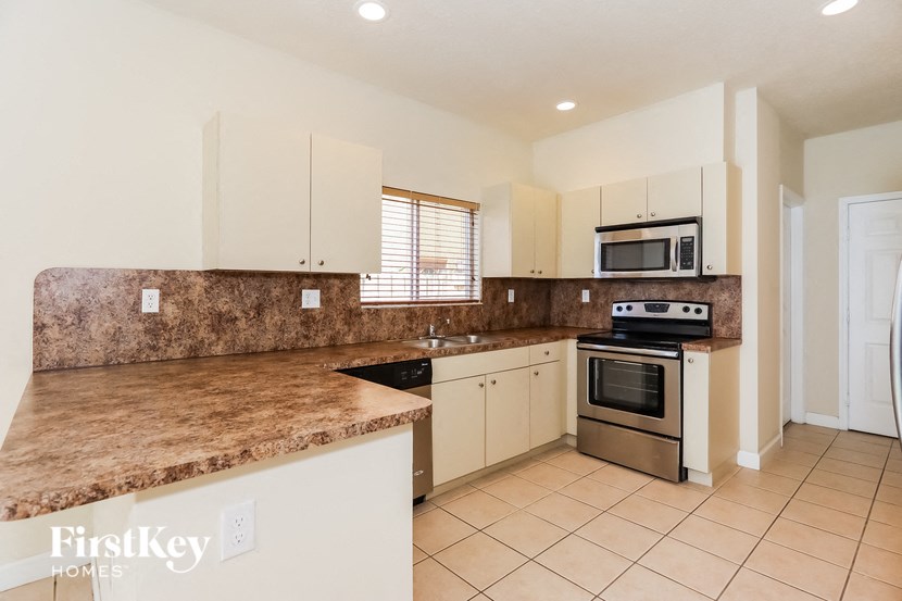a kitchen with granite counter tops and white cabinets