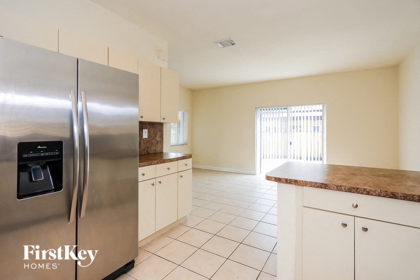 a kitchen with white cabinets and a stainless steel refrigerator