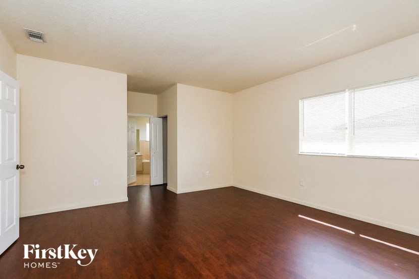 an empty living room with wood floors and white walls