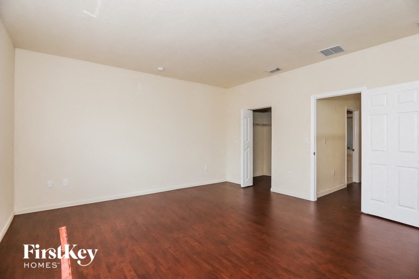 an empty living room with wood flooring and white walls