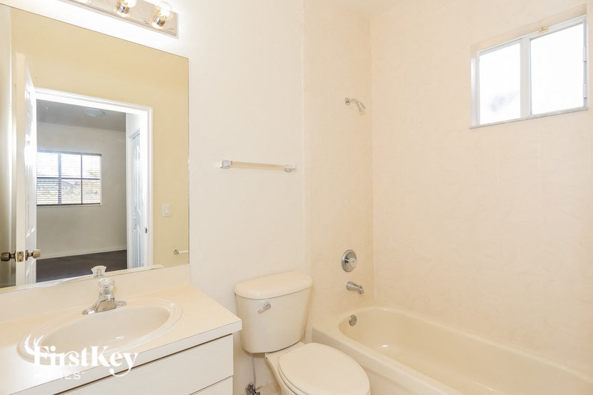 a white bathroom with a tub and a toilet and a sink
