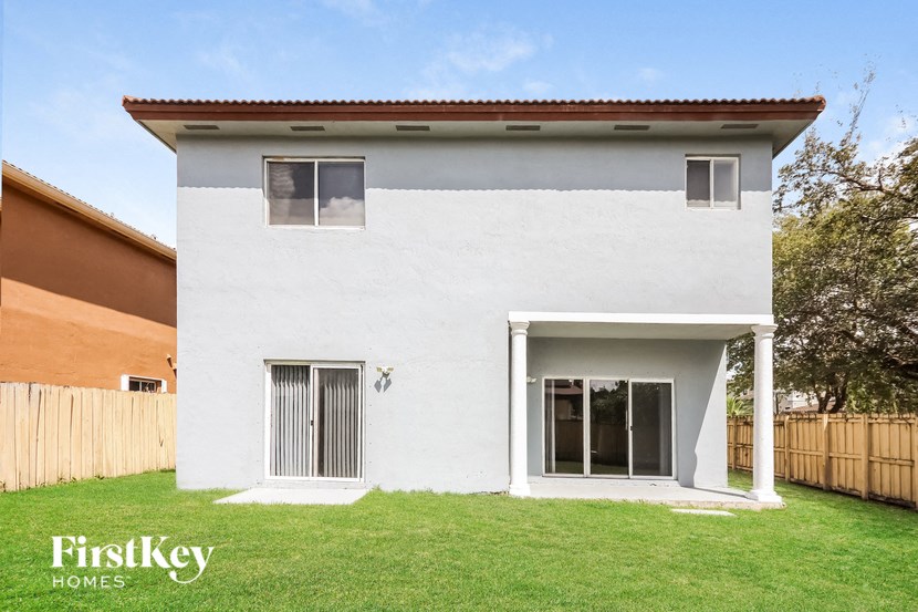 the exterior of a white house with a yard and grass