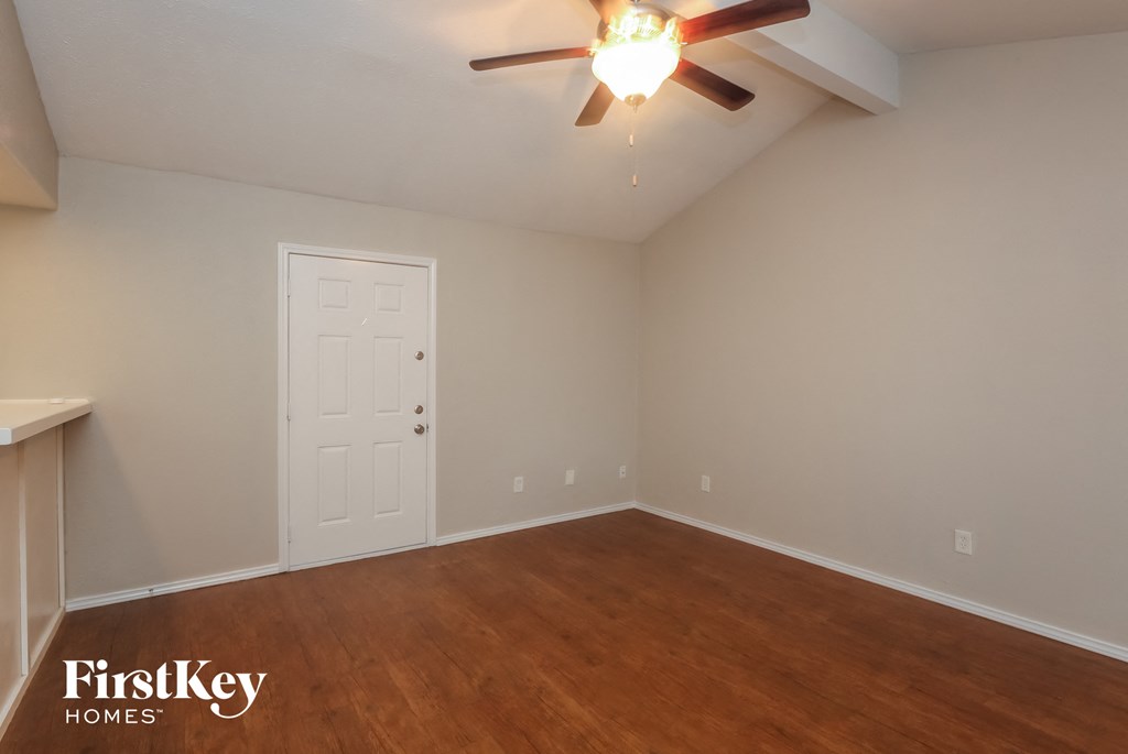 A room with a ceiling fan and a door.