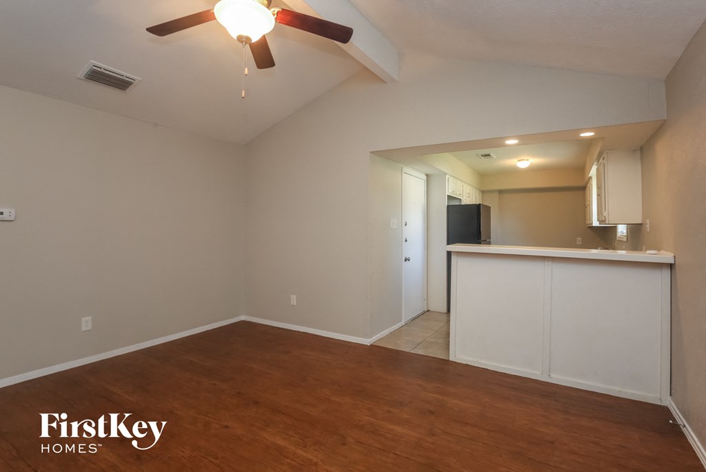 A room with wooden floors and a ceiling fan.