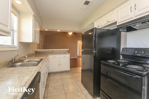 A kitchen with a black refrigerator and stove.