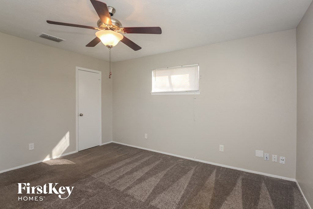 A room with a ceiling fan and a window.
