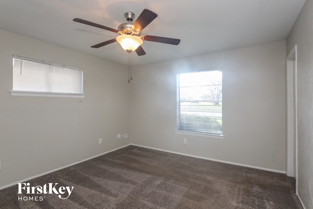A room with a ceiling fan and a window.