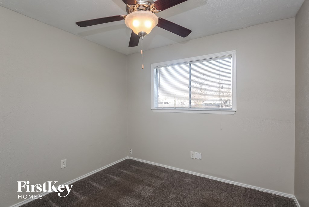A room with a ceiling fan and a window.