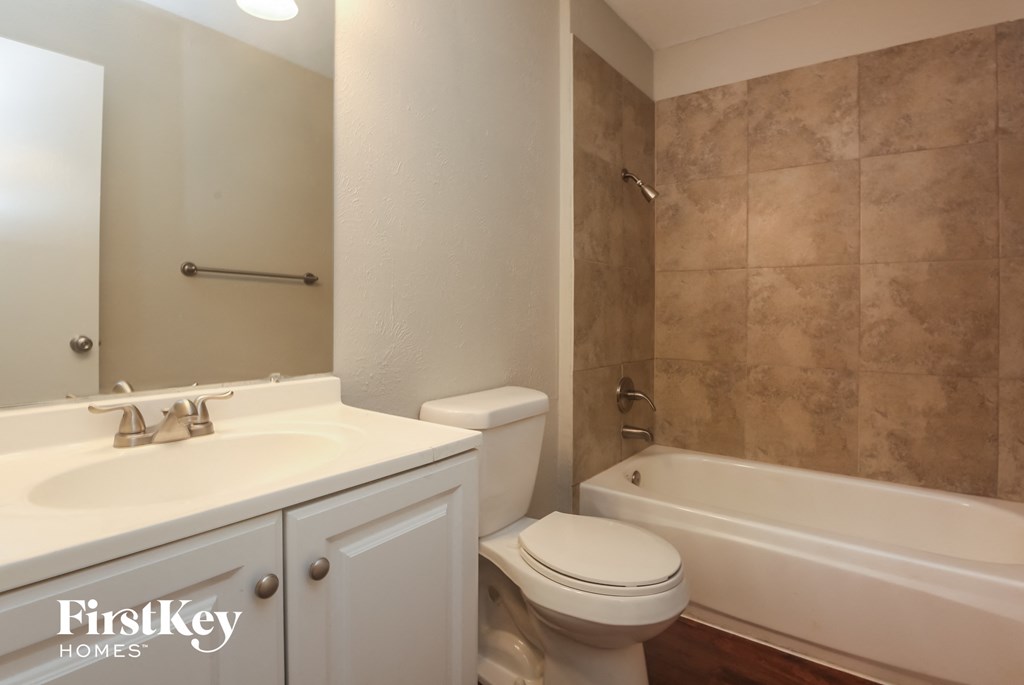 A bathroom with a white sink, toilet and tub.