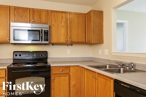 A kitchen with wooden cabinets and a stove top oven.