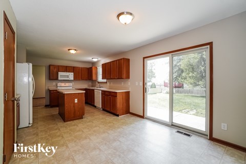 A kitchen with wooden cabinets and a refrigerator.