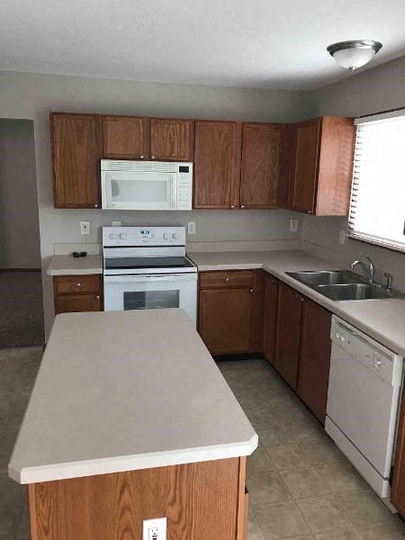 A kitchen with a white oven and a white dishwasher.
