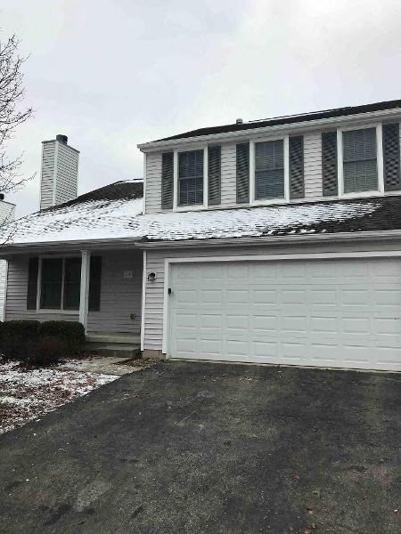 A house with a white garage door and a chimney.