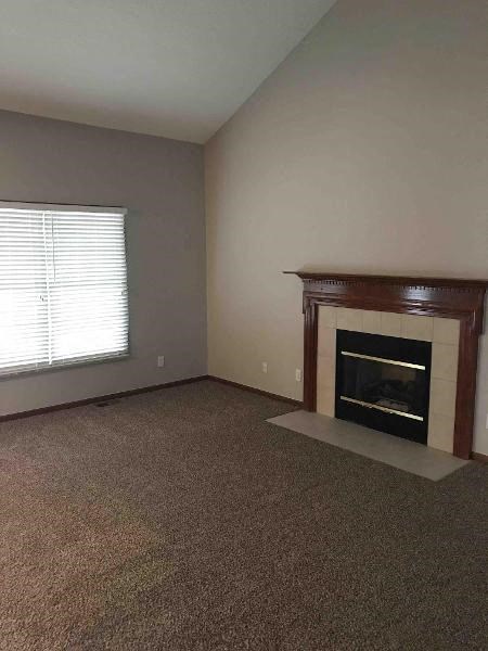 A room with a fireplace and a window with blinds.