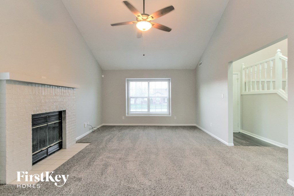 the living room with fireplace and ceiling fan
