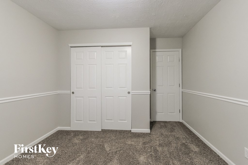 a bedroom with two closets and a carpeted floor