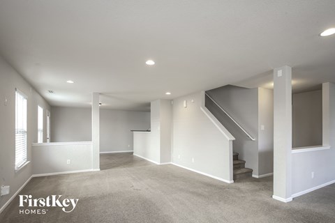 a living room with carpet and stairs in a new home