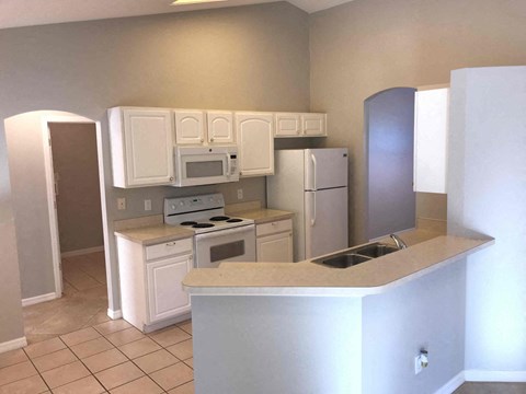 a kitchen with white cabinets and a refrigerator