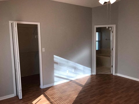 a living room with a hard wood floor and a door to a bathroom