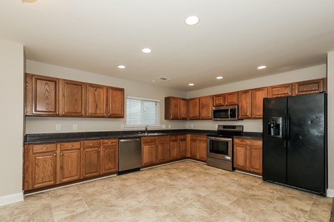 A kitchen with wooden cabinets and black appliances.