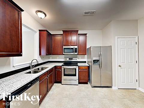 A kitchen with wooden cabinets and a stainless steel refrigerator.
